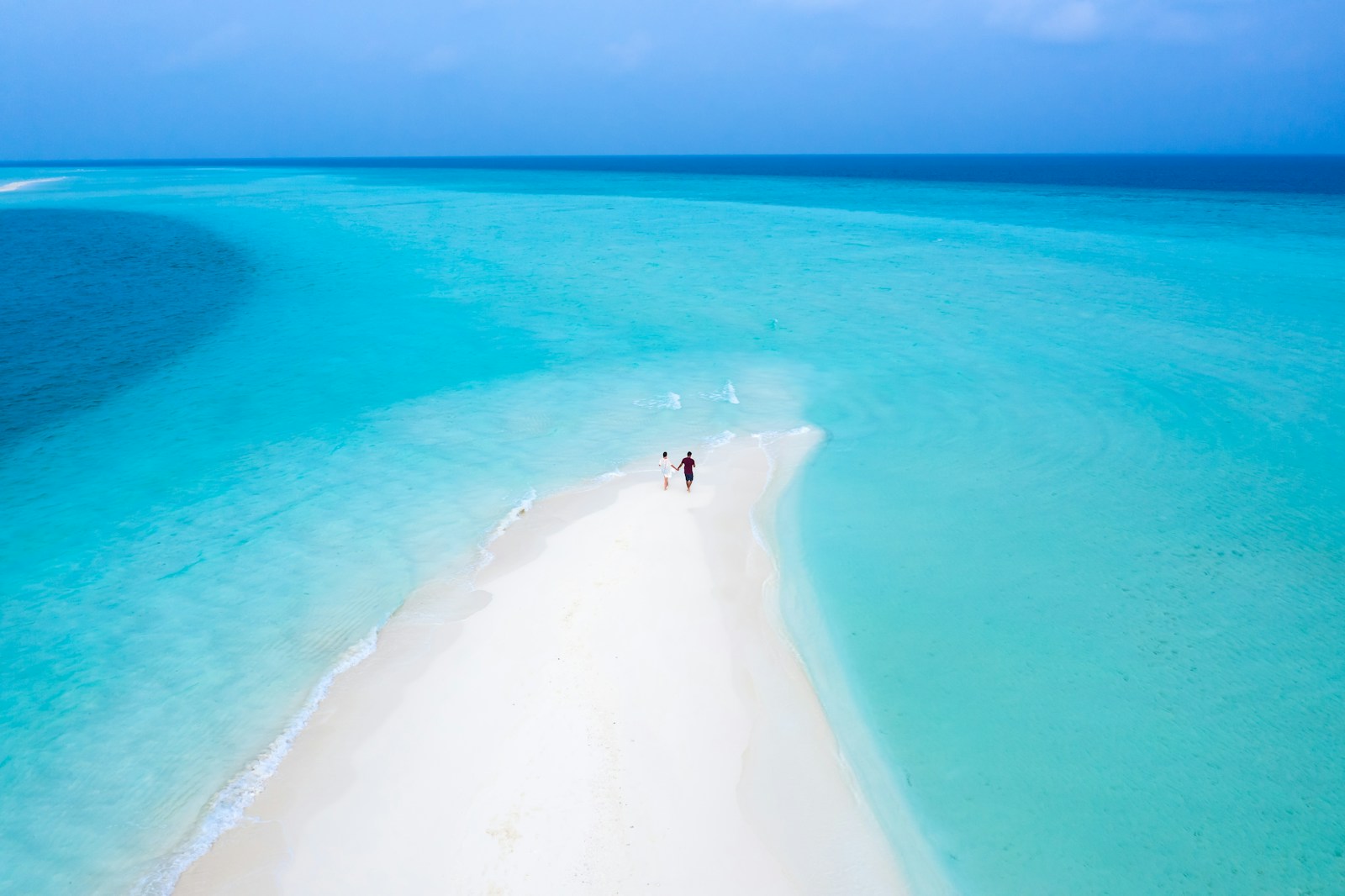 person in black shirt standing on white sand beach during daytime